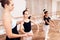 The trainer of the ballet school helps young ballerinas perform different choreographic exercises.