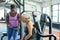 Trainer discussing over clipboard with active senior woman in fitness studio