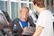 Trainer in fitness center advising senior man