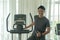 Trainer handsome man standing in fitness holding his thumbs up on the exercise machines. sport, lifestyle concept