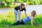 trainer helps to correctly perform yoga exercises to a mature woman, sports in the park