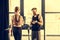 Trainer instructing trainee standing on treadmill in gym