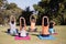 Trainer teaching children stretching while sitting on mat