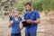 Trainer and woman discussing over clipboard during obstacle course