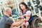 Trainer with woman in wheelchair lifting weight in gym. well being of disabled people