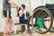 Trainer with woman in wheelchair lifting weight in gym. well being of disabled people