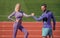 training with coach. fitness partners. athletic man and woman compete in armwrestling. male and female coach on stadium