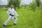 Training in the fresh air. A karate trainer stands in a karate pose and looks at the camera. White kimono. Black belt in karate. P