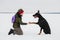 Training and playing with dogs Dobermans on a snowy field