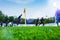 Training soccer players on football stadium. Green grass at foreground. Defocused.