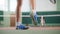 Training on the tennis court. Two young men in a good shape playing tennis. Feet in blue boots in focus