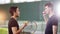 Training on the tennis court. Two young men talking to each other. One man throws up the ball