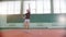 Training on the tennis court. Young man throws the ball in the air and innings it