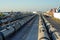 Trains carrying fluids merge at the point of a large fuel storage tank.