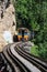 Trains running on death railways track crossing kwai river in kanchanaburi