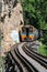 Trains running on death railways track crossing kwai river in kanchanaburi thailand