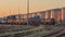 Trains with silos of a petrochemical plant on the background lit by warm light, Port of Antwerp, belgium