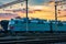 Trains and wagons, railroad infrastructure, beautiful sunset and colorful sky, transportation and industrial concept