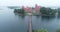 Trakai, Lithuania: medieval gothic Island castle, located in Galve lake and town in the background. Aerial above summer