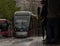 Tram approaching the stop, rainy day.