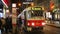 A tram arrives at a public transport stop at night.