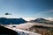 Tramping rescue helicopter in wild mountains snowy landscape with deep blue lake above the clouds, rescuing trampers, New Zealand