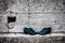 Trampled discarded shoes against the background of a limestone wall. Still life