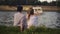 Trandy couple talking by the river. Holidays, vacation, love and people concept - happy teenage couple sitting by river Visla