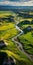 Tranquil Aerial Photo Of Green River Flowing Through Vibrant Grassland