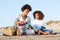 Tranquil African American mother and daughter on picnic on beach