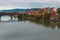 Tranquil autumn morning in Maribor. Beautiful Old Bridge reflected in water of the Drava River.