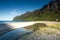 Tranquil beach with mountains and solitary person