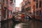 Tranquil black gondola on busy Venice canal, capturing the city's unique charm.