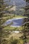 Tranquil blue lake viewed between trees and fields