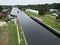 Tranquil canal winding its way through a tranquil suburban neighborhood, lined with lush trees