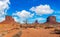 Tranquil desert scene with sparse shrubs and a barren landscape set against a brilliant blue sky,