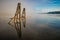 Tranquil foggy seascape with ruined pier metal pieces in a reflective seawater