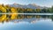 Tranquil high tatra lake autumn sunrise with colorful mountains and pine forest for nature hiking