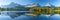 Tranquil high tatra lake with autumn sunrise, mountain reflections, and serene natural beauty