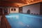 Tranquil Indoor Swimming Pool with Rustic Charm, Warm Lighting, and Decorative Elements
