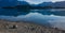 Tranquil lake with mountain reflections and pebble shoreline