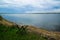 Tranquil lake view. Folding fisherman chair at the coast. Blue cloudy rainy sky