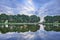 Tranquil landscape with a canal, trees, blue sky and dramatic clouds, Tilburg, Netherlands