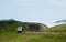 Tranquil landscape of mountain top with tiny farmhouse on the meadow in French Pyrenees. Scenic pasture at summertime, south of