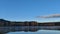 Tranquil meditative misty scenery of glacial lake with pointy fir tops reflection at early morning