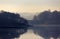 Tranquil Misty morning layered landscape of trees reflected in a still lake