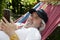 Tranquil moments for the old man in the hammock. Leisurely retreat for the old man in his hammock. Relaxed old man lounging in a