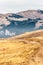 A tranquil mountain scene. Brown grass on a hill. Red guiding si