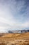 A tranquil mountain scene with clouds cover on a hill. Red guiding signs for snow