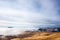 A tranquil mountain scene with clouds cover on a hill. Some cabins in the backgroud